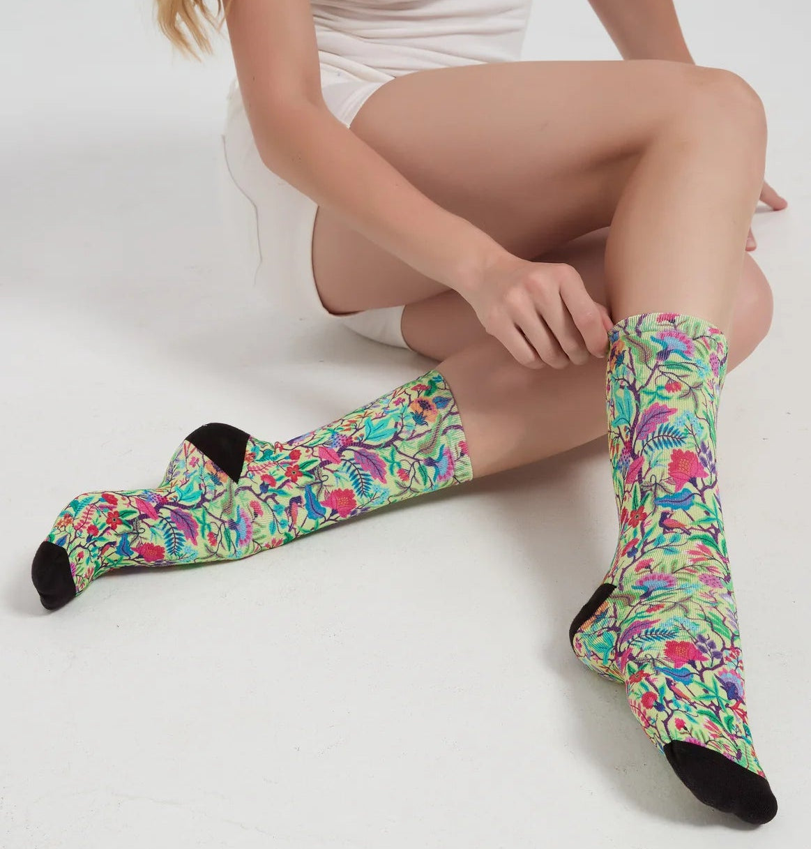Person wearing colorful floral-patterned socks on a white background