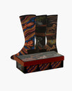 Three pairs of patterned crew socks displayed behind a decorative gift box on a light gray background. The socks feature intricate Aboriginal-style artwork with snakes, kangaroo-like figures, and geometric designs in red, orange, yellow, blue, black, and white.
