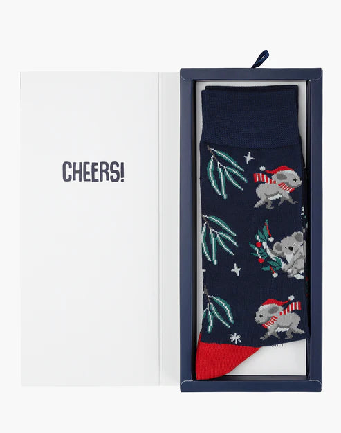 Navy blue sock with koala design in a box labeled 'Cheers!' on a white background
