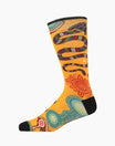 A single crew sock with a vibrant yellow background featuring an Aboriginal-inspired pattern of a snake, sun, and geometric dots in red, blue, green, and black, with solid black heels, toes, and cuffs.