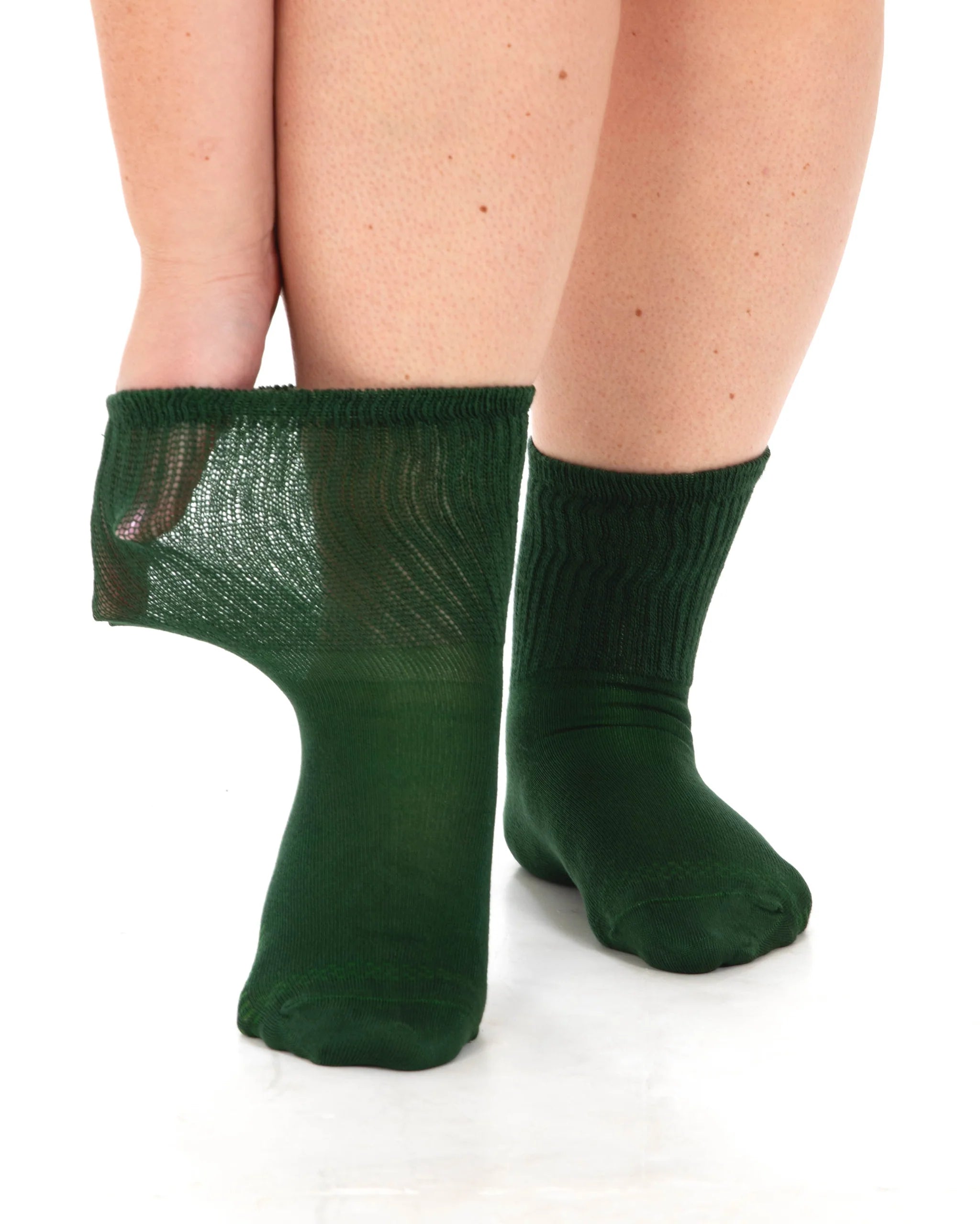 Green socks worn by a person on a white background