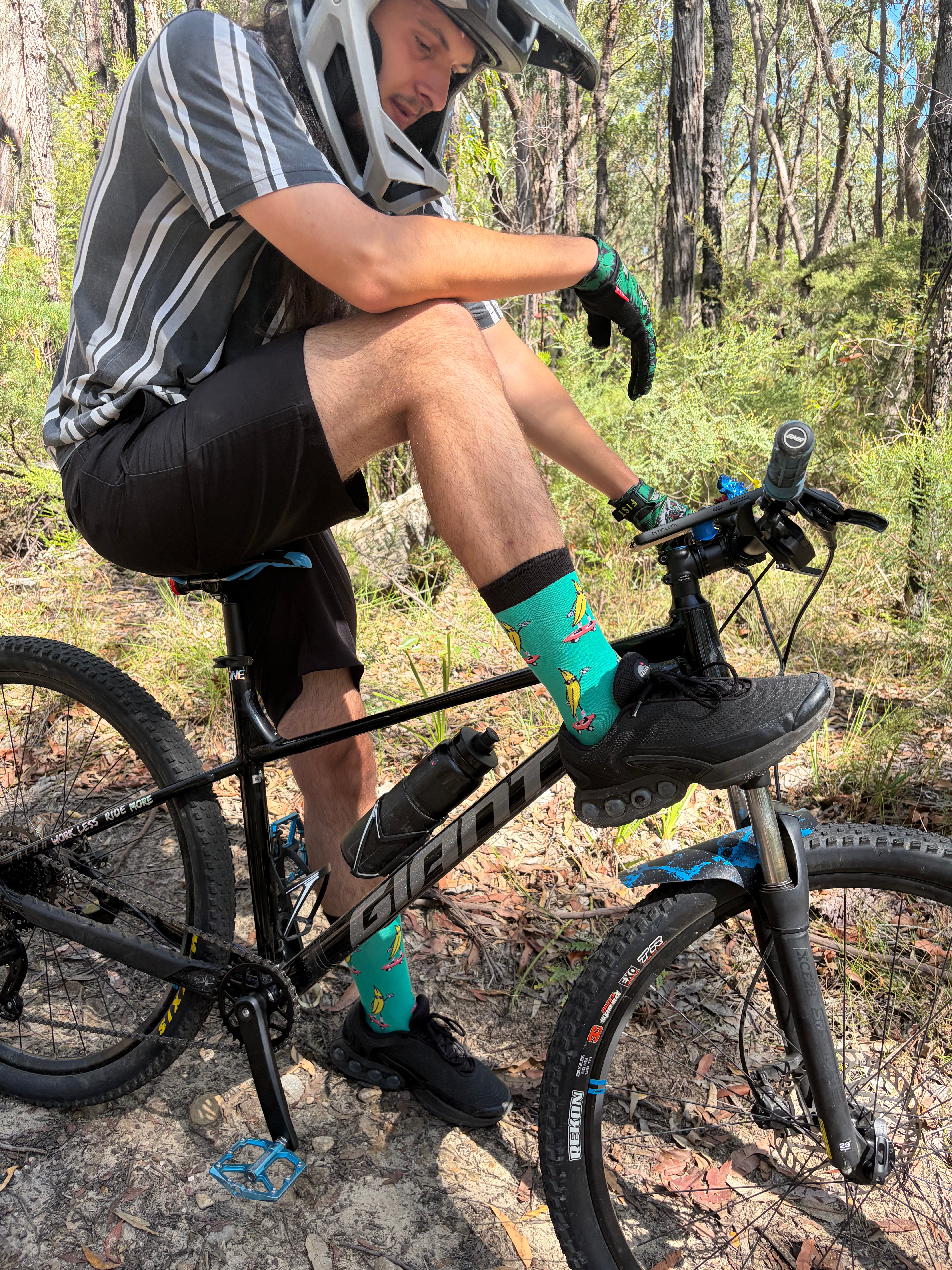 Person wearing Peeling Out socks on a mountain bike in a forest setting