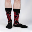 Black socks with red octopus design worn by a person on a white background