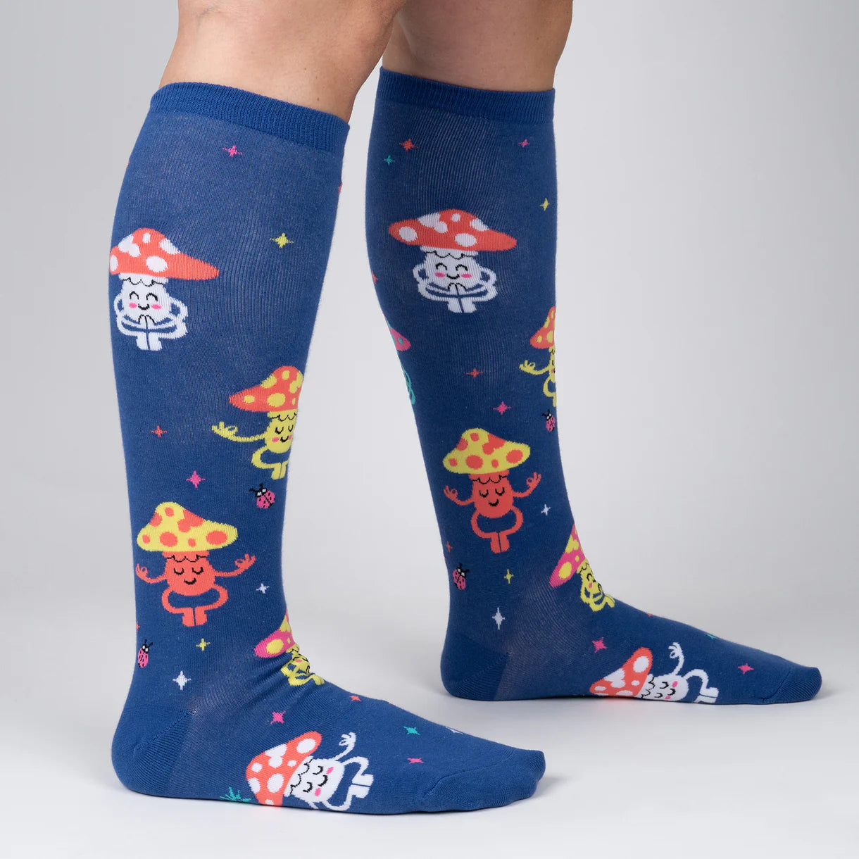 Blue knee-high socks with colorful mushroom design on a gray background
