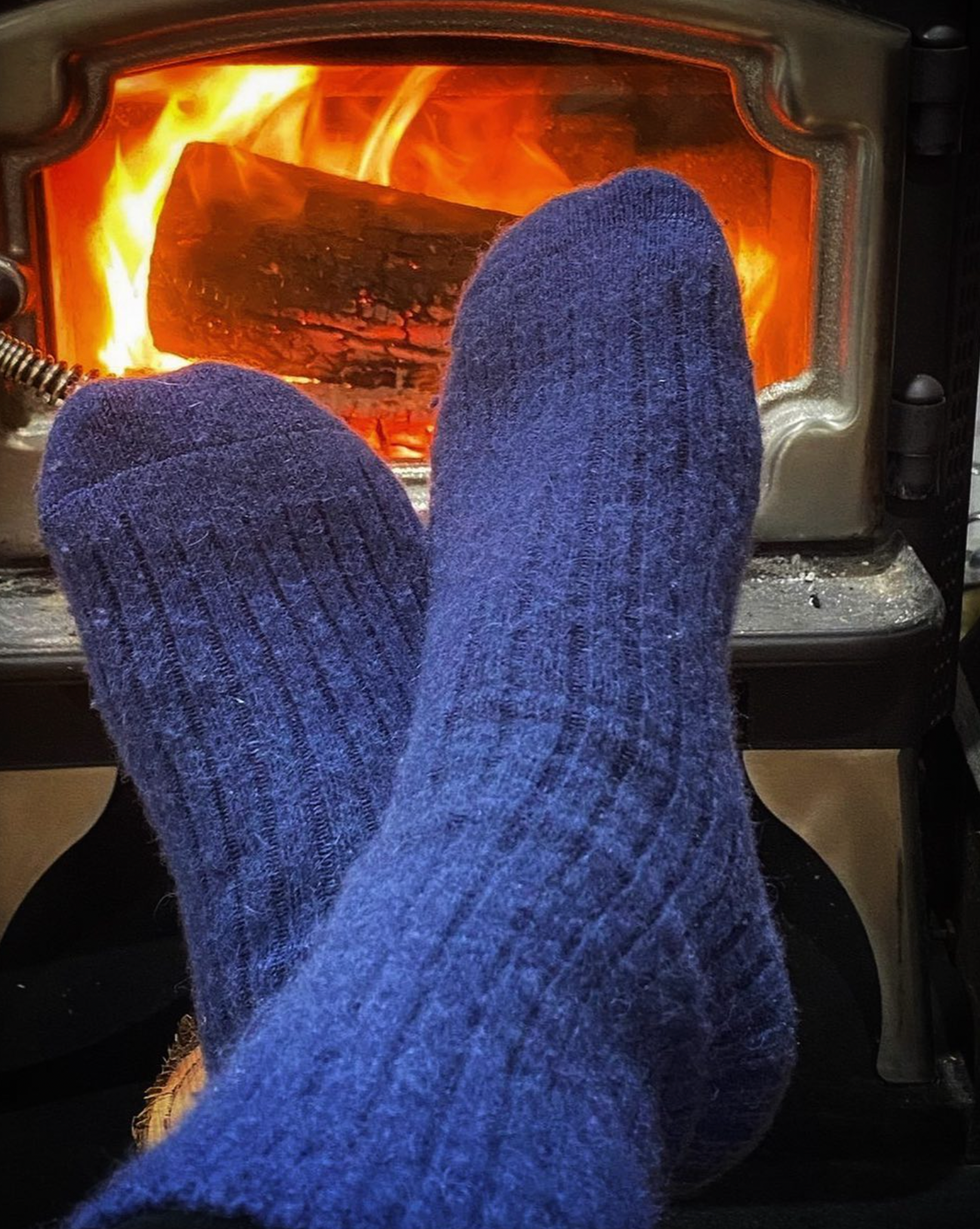 Blue socks in front of a burning fireplace