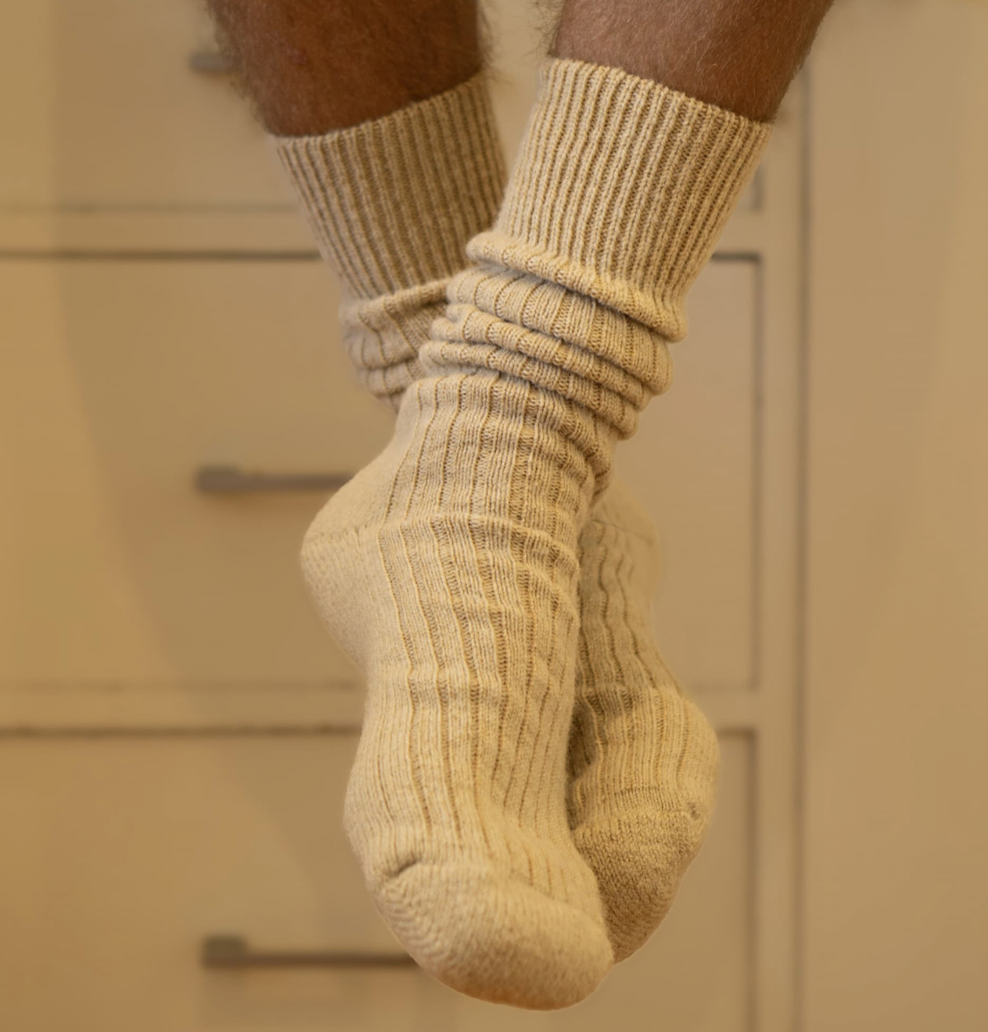 Close-up of feet wearing beige socks with a neutral background