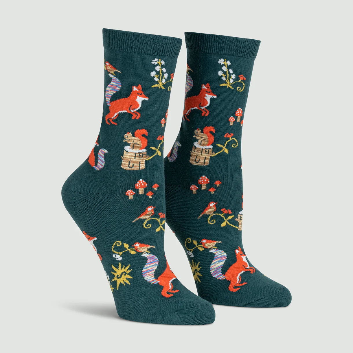 Pair of socks with fox and mushroom pattern on a light gray background