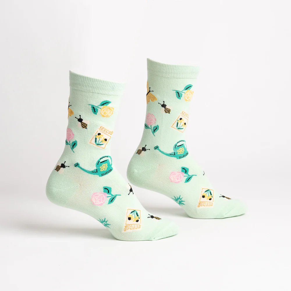 Mint green socks with garden-themed design on a white background