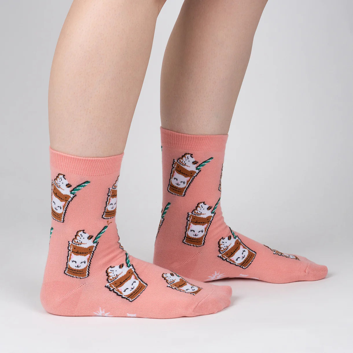 Pink socks with cat-themed designs on a plain background