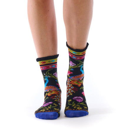 Colorful patterned socks with a peacock worn by a person on a white background
