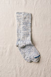 Pair of indigo socks on a beige fabric background