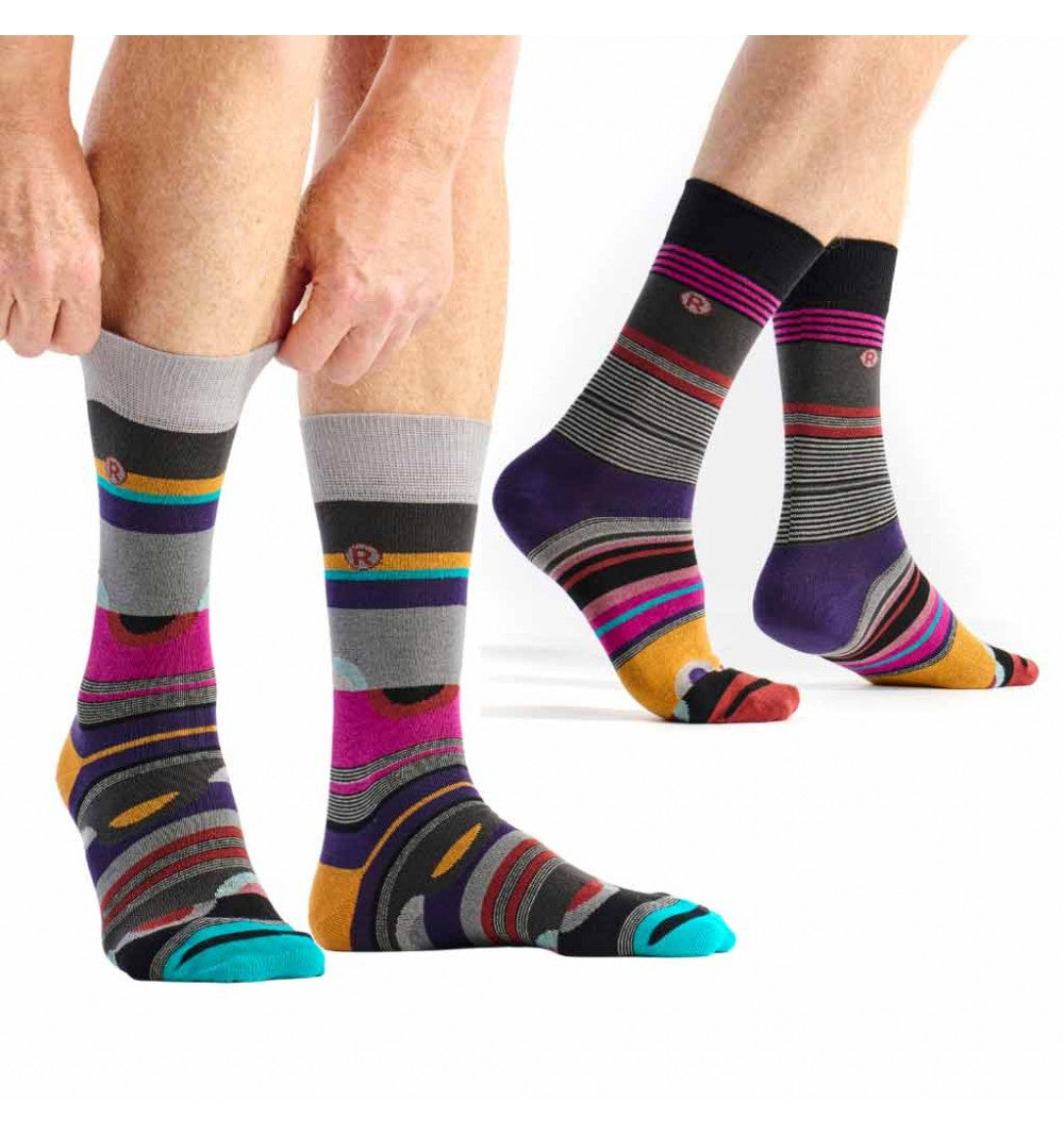 Colorful striped socks being worn on a white background