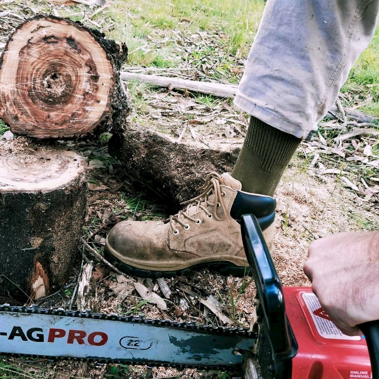 Man with chain saw wearing khaki green grass seed sock - The Sockery