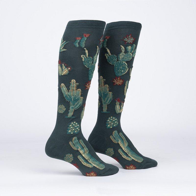 A green knee high sock with cacti all over.
