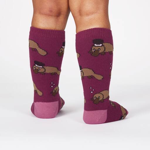 A toddler wearing purple knee high socks with platypus all over, some wearing top hats, back view - The Sockery