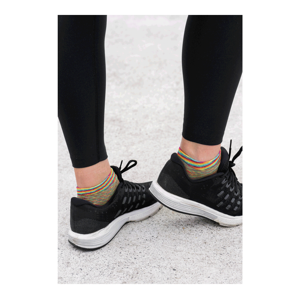 woman in black leggings wearing rainbow sun socks