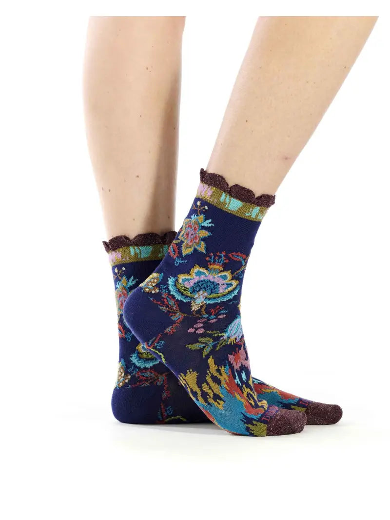 Colorful patterned socks worn by a person on a white background