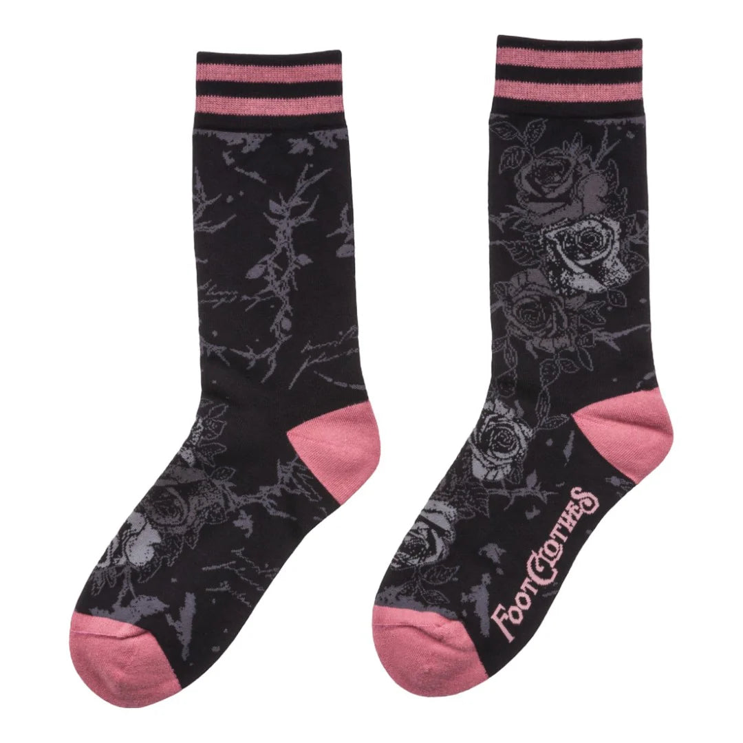 Black socks with pink accents and floral patterns on a white background
