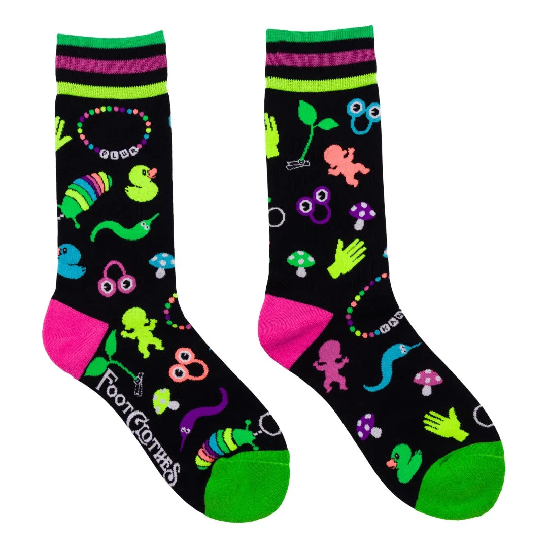 A pair of black crew socks with a colorful, whimsical monster and nature-themed print, featuring bright neon green, pink, and purple accents. The brand name 'Foot Clothes' is printed in white script on the sole of one sock.