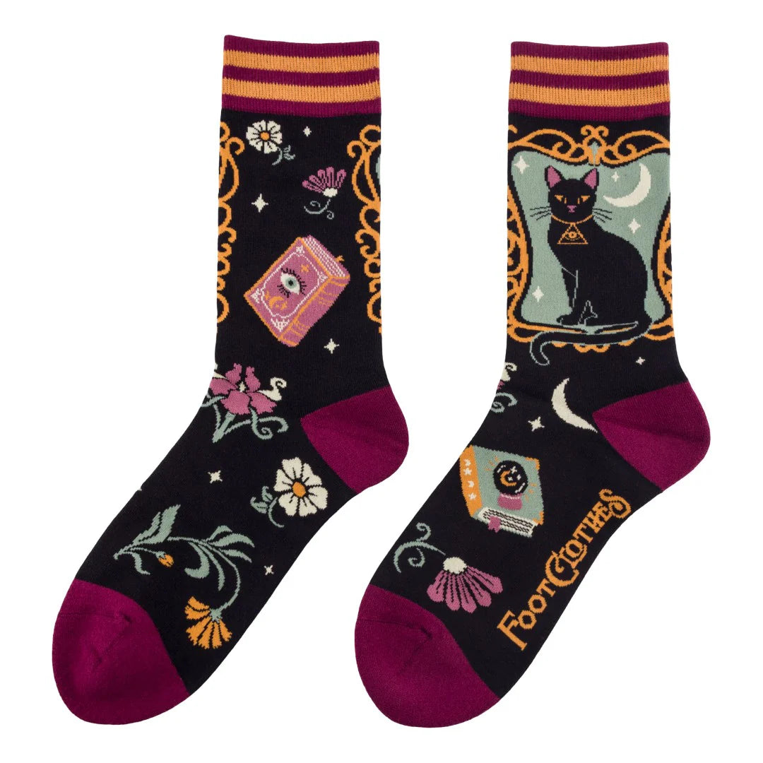 Pair of socks with black cat and tarot card design on a white background