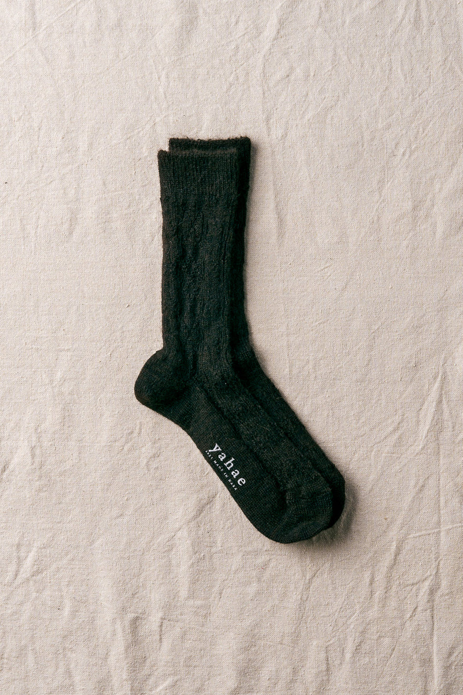brown sock with a brand label on a beige textured background