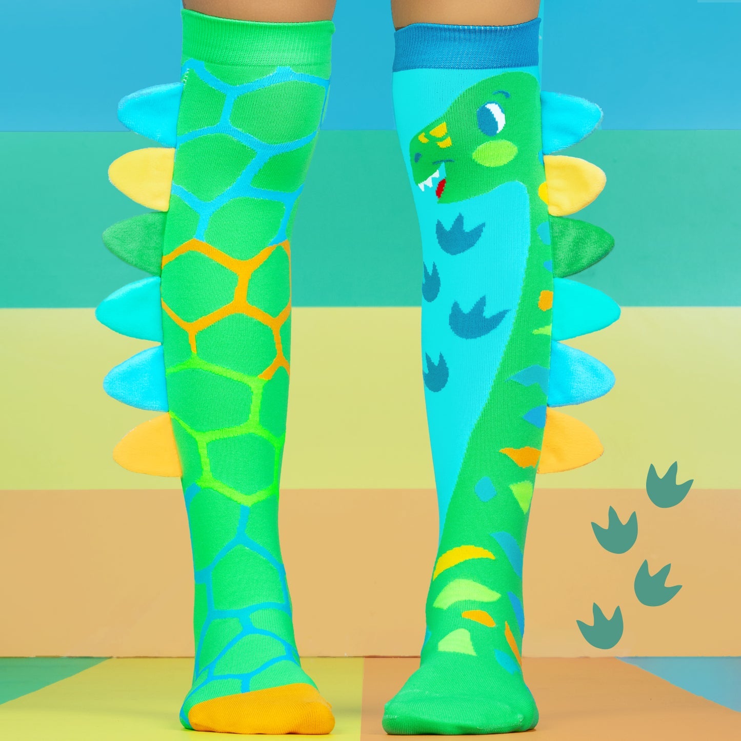 Colorful dinosaur-themed knee-high socks on a colorful background
