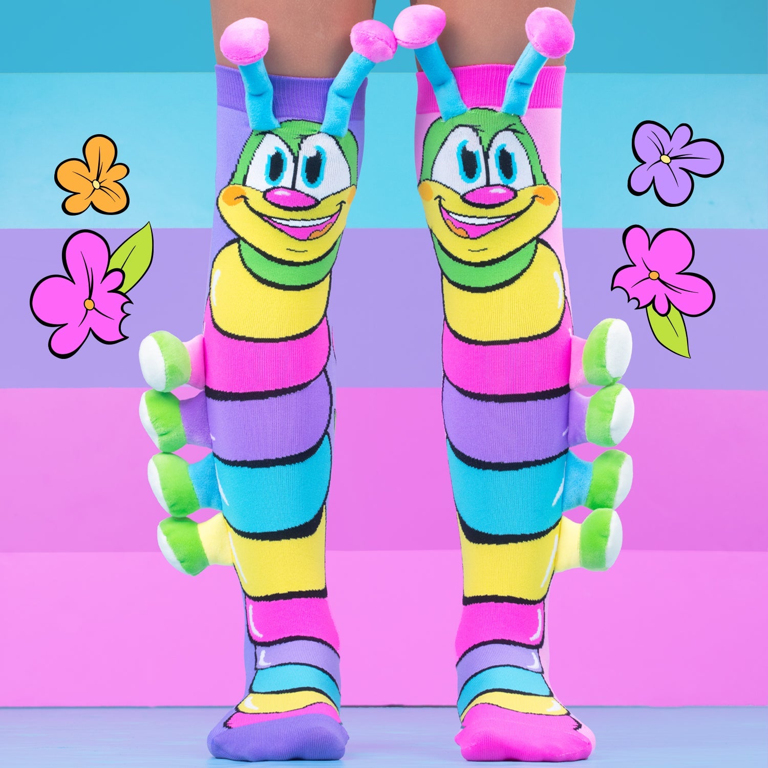 Colorful caterpillar-shaped socks worn by a person on a multicolored background with flowers.