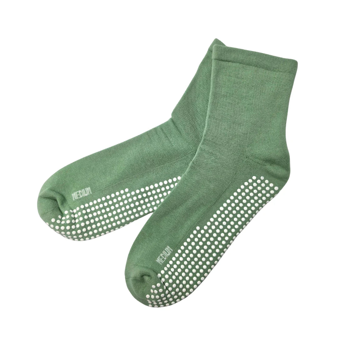 Green socks with non-slip dots on a white background