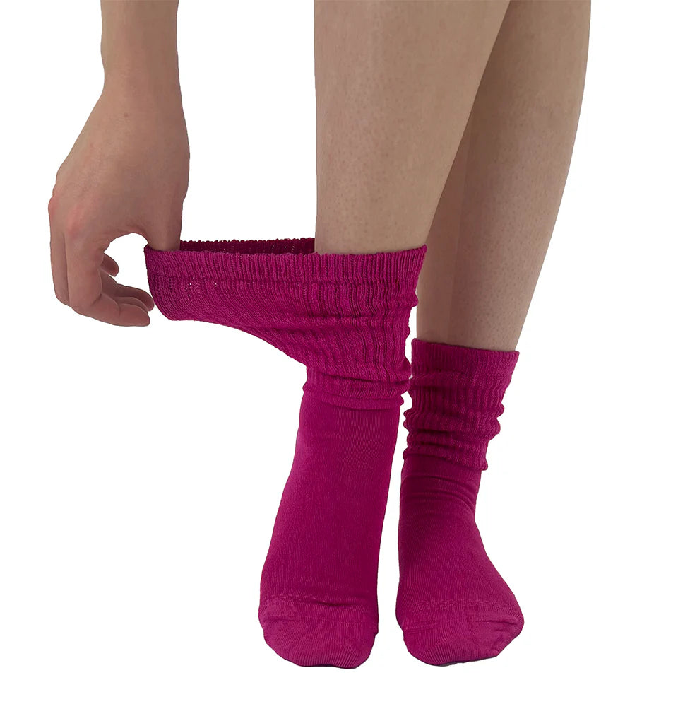 Person wearing bright pink socks on a white background