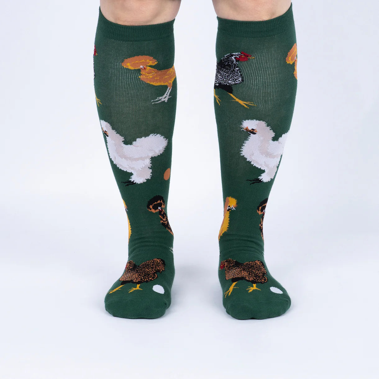 Green knee-high socks with chicken pattern worn by a person on a white background