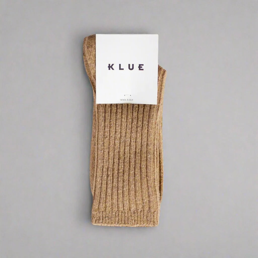 Beige sock with KLUE label on a gray background