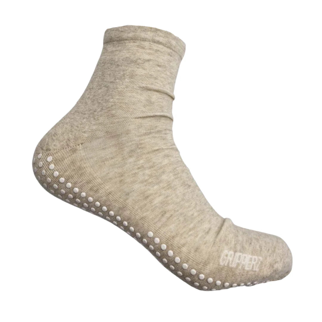 Beige sock with grip dots on a white background