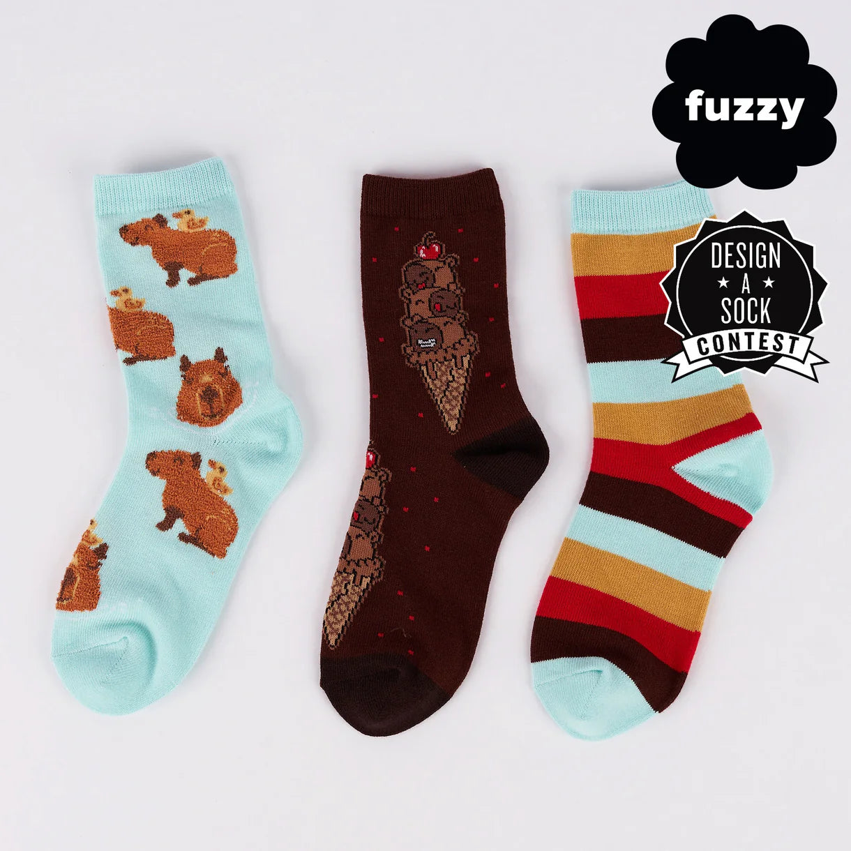 Three pairs of socks with different designs on a light gray background, featuring the brand 'fuzzy'.
