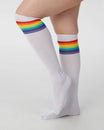 White knee-high socks with rainbow stripes on a light gray background