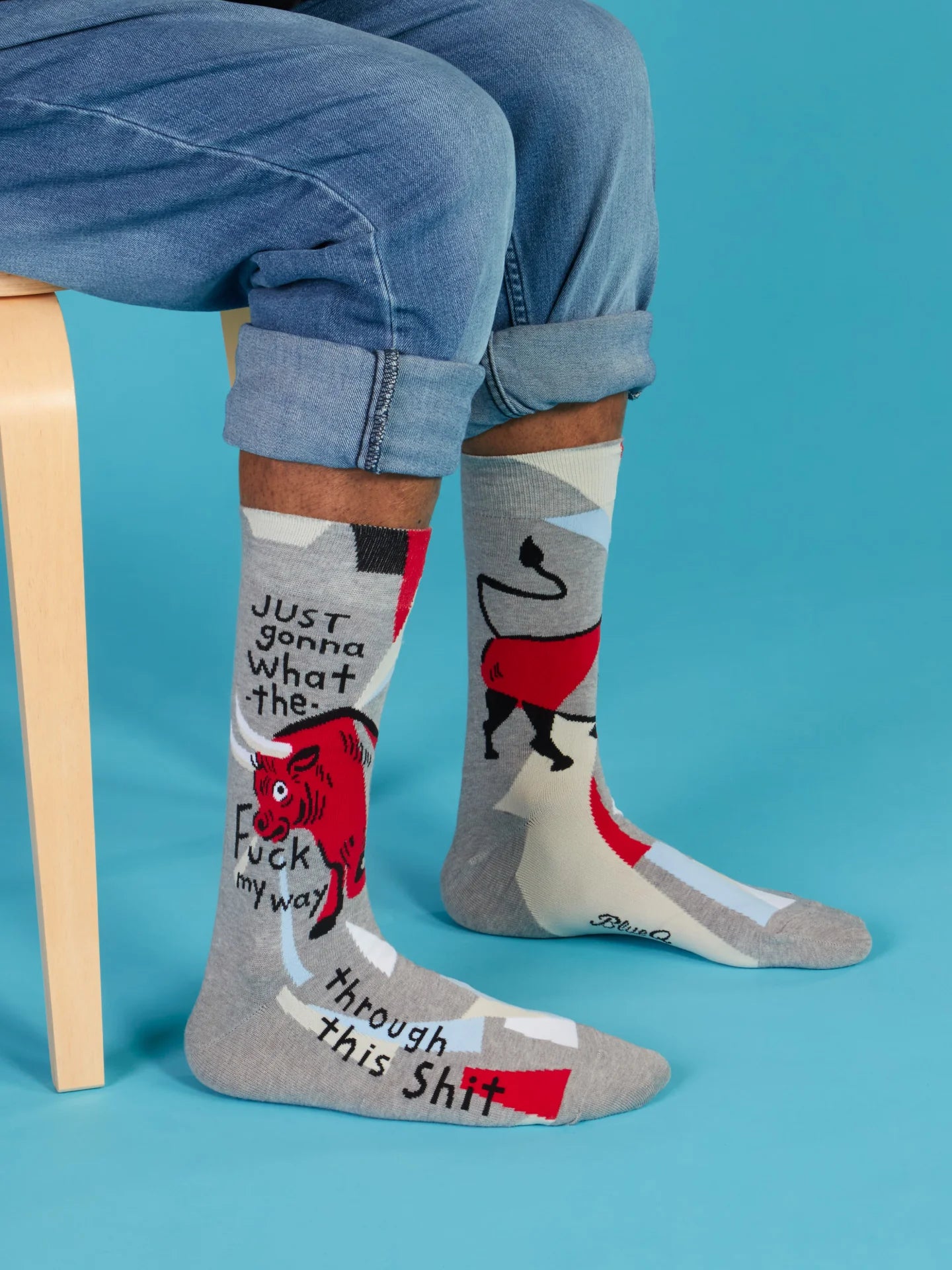 Person wearing socks with graphic designs and text on a blue background