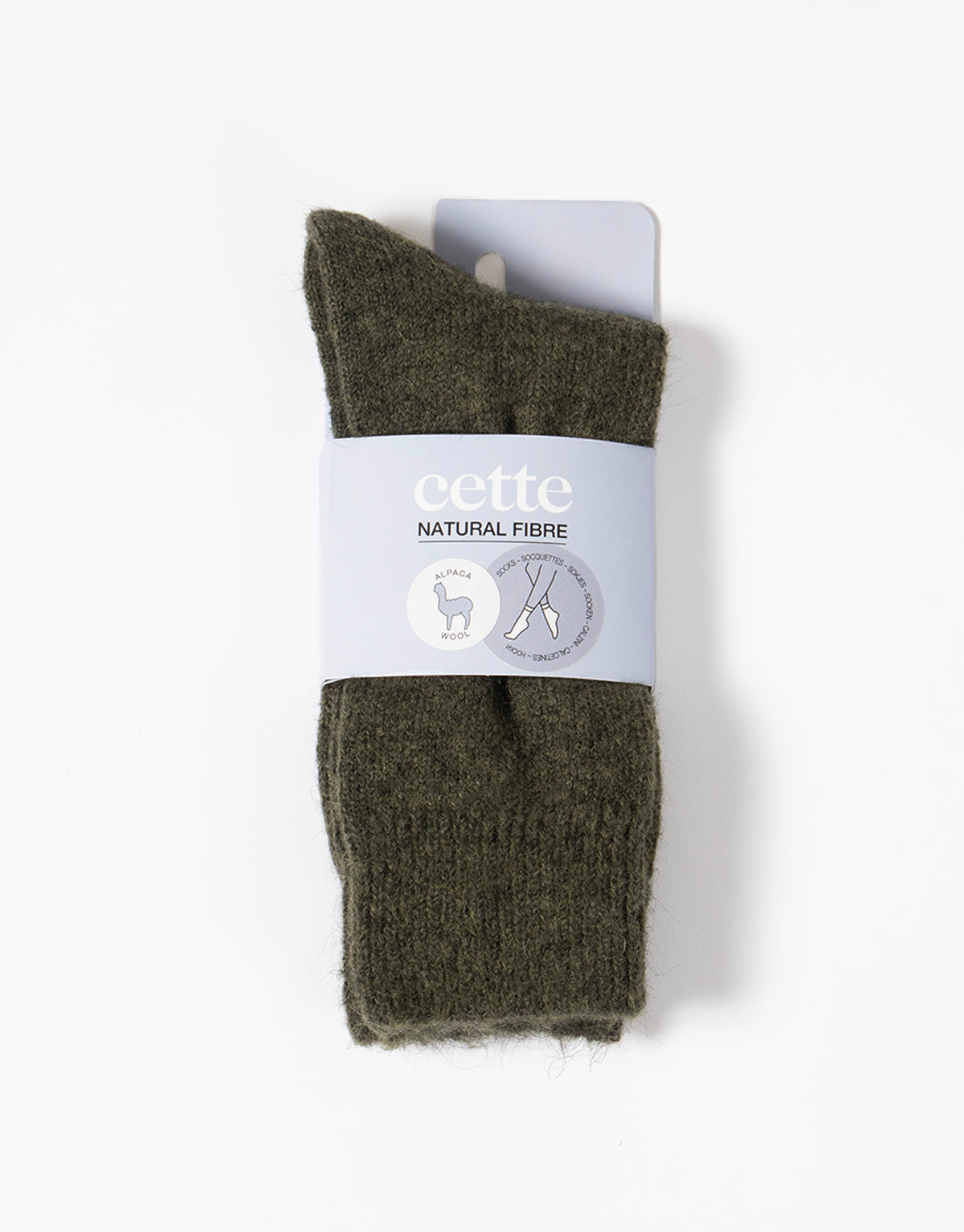 Pair of green socks with a 'cette' label on a white background