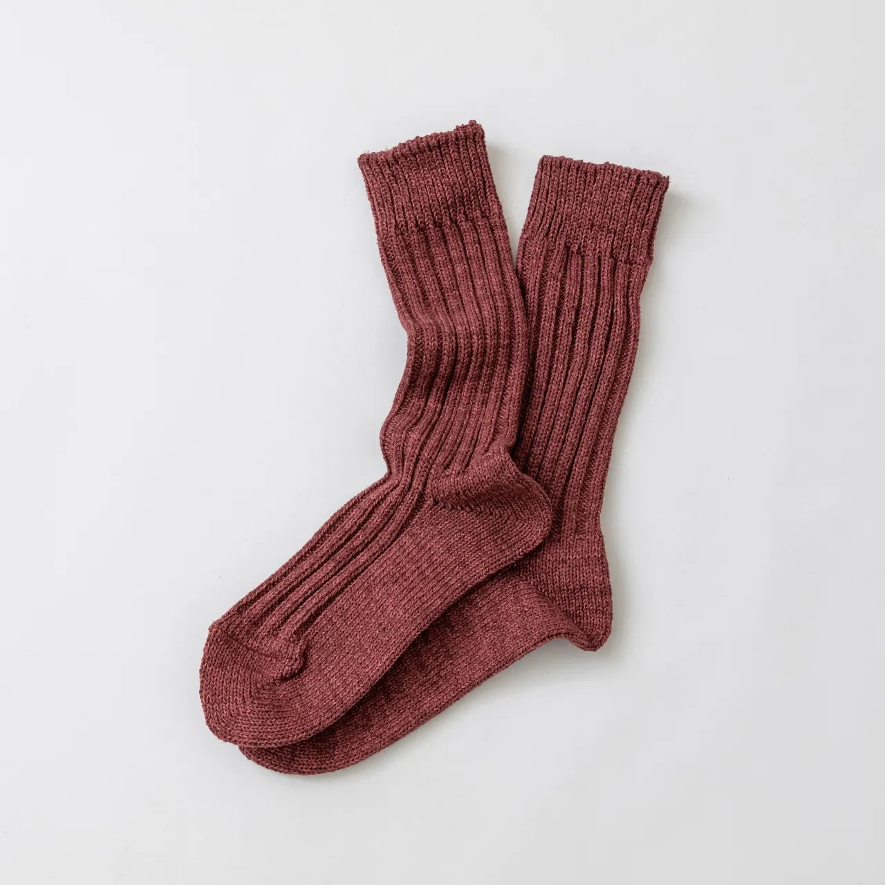 Pair of maroon socks on a light gray background