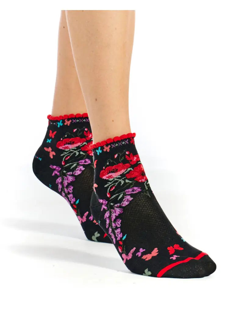 Black socks with colorful floral and butterfly designs on a white background