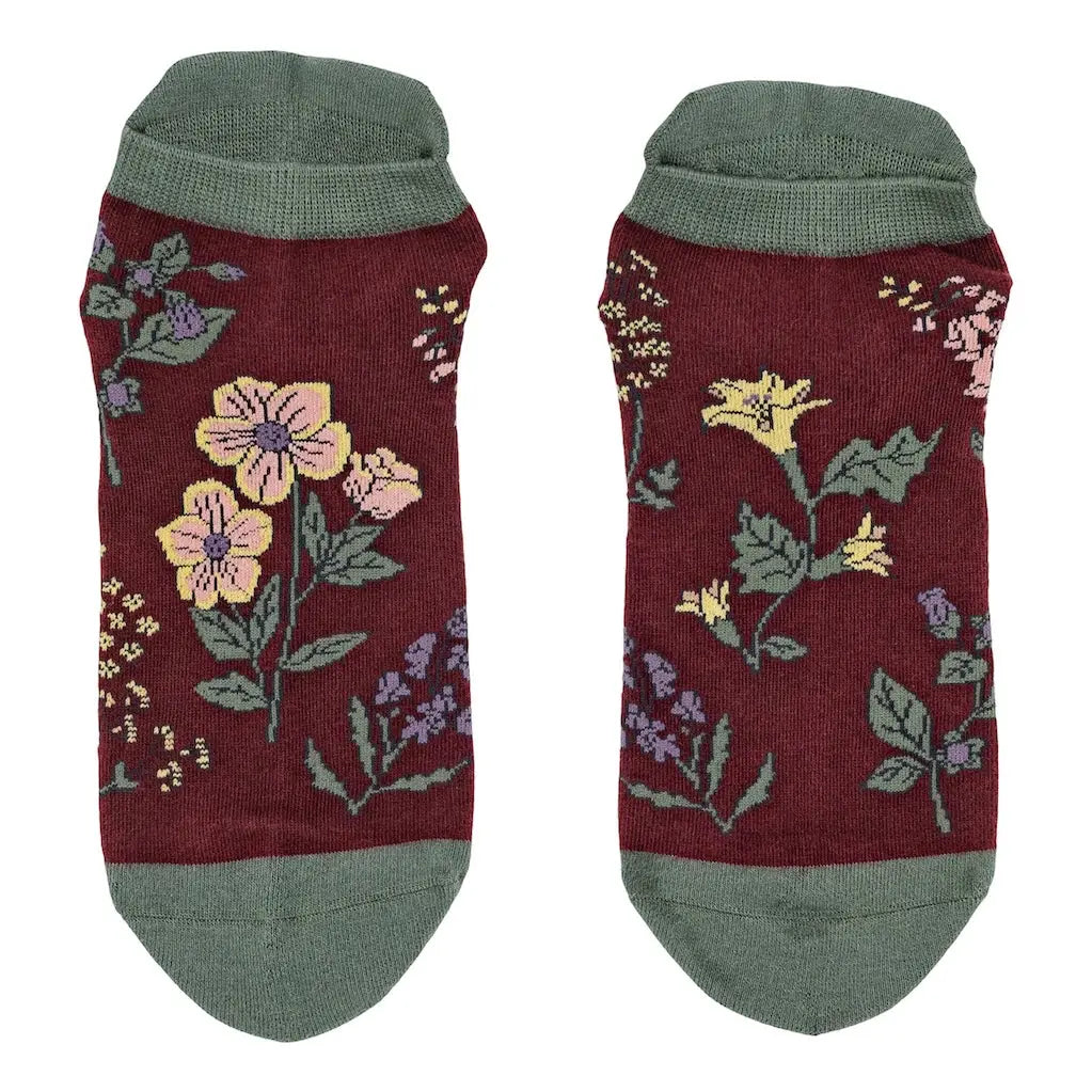 Pair of maroon socks with floral patterns on a white background