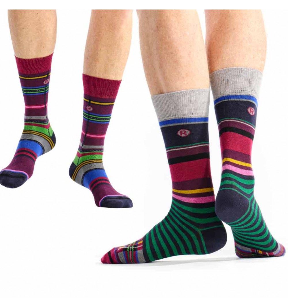 Colorful striped socks being worn on a white background