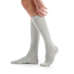 Gray knee-high socks worn by a person on a white background