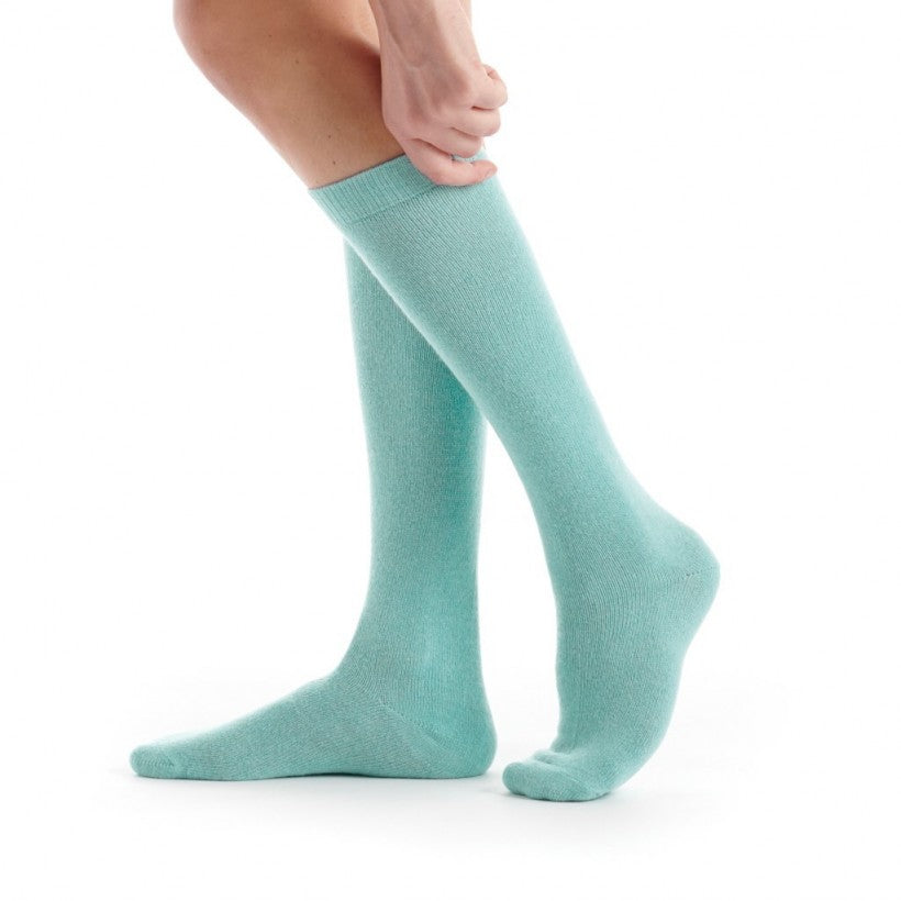 Light green knee-high socks worn by a person on a white background