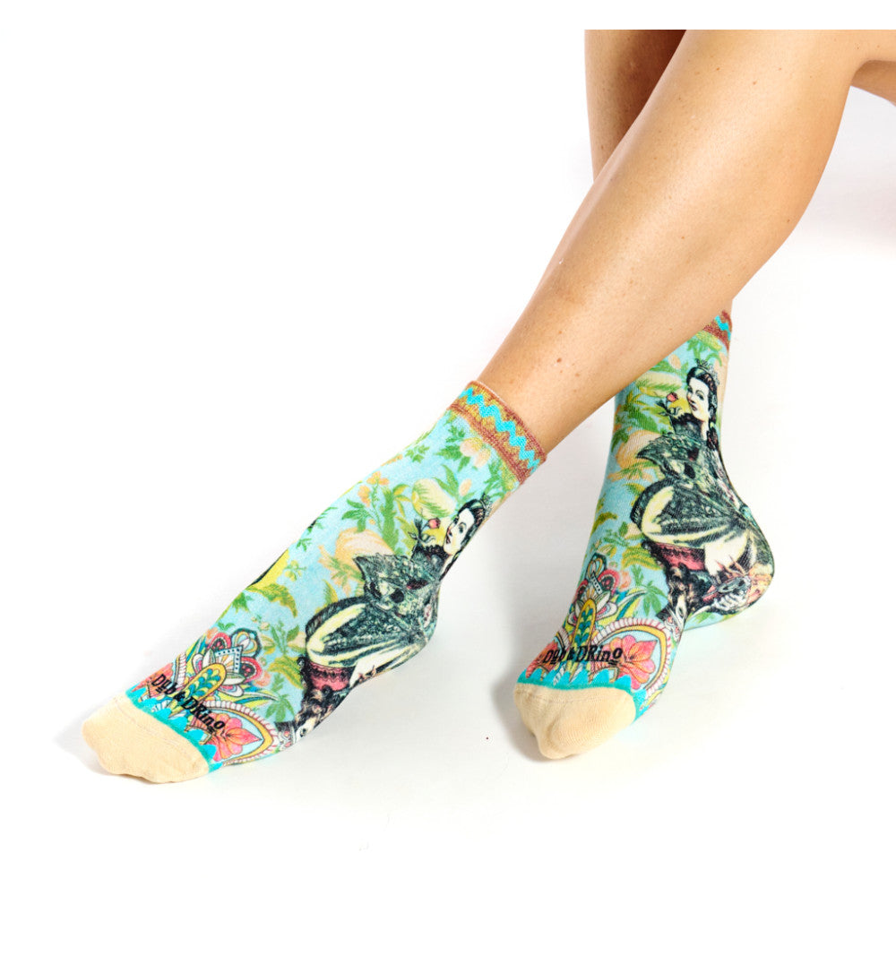 Colorful socks with a floral and cat design worn by a person on a white background