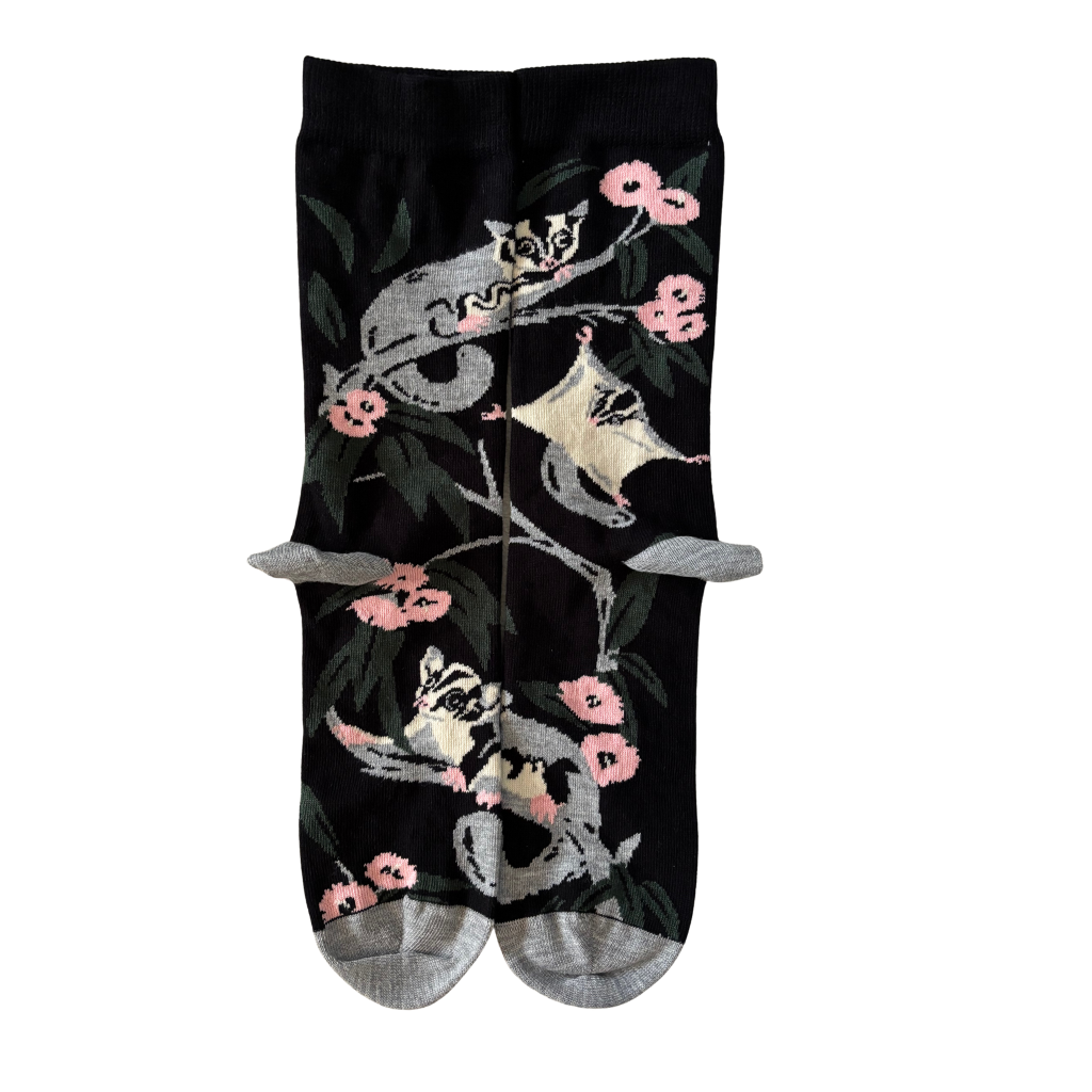Black socks with white possum design and pink flowers on a white background