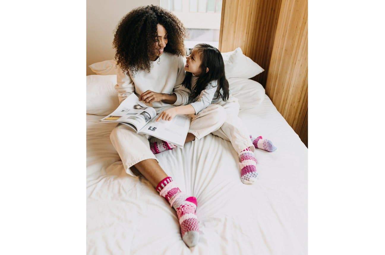 women and child in bed wearing recycled fibre socks
