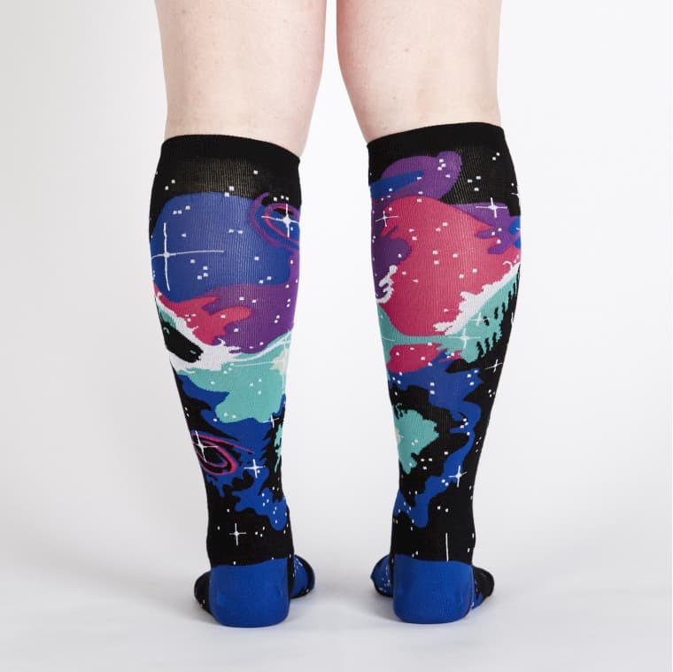 Back view of knee high socks in black, purple, pink and blue, along with turquoise and white. There is a black horse head and white stars - The Sockery