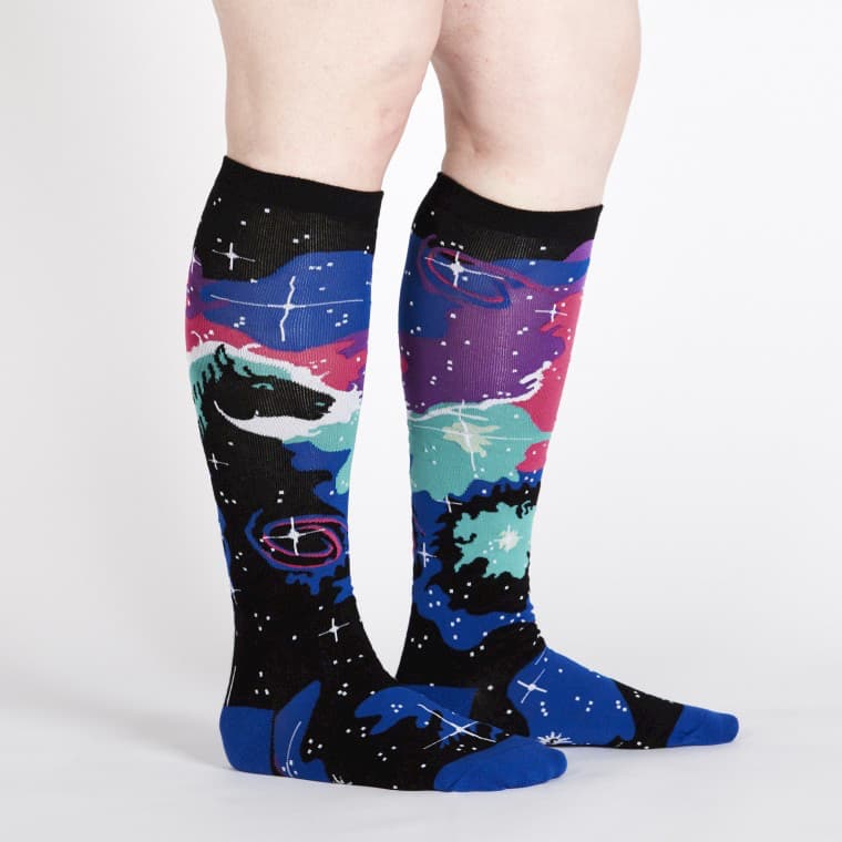 Side view of knee high socks in black, purple, pink and blue, along with turquoise and white. There is a black horse head and white stars - The Sockery