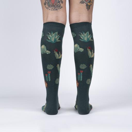 A person wearing green knee high socks with cacti all over, back view - The Sockery