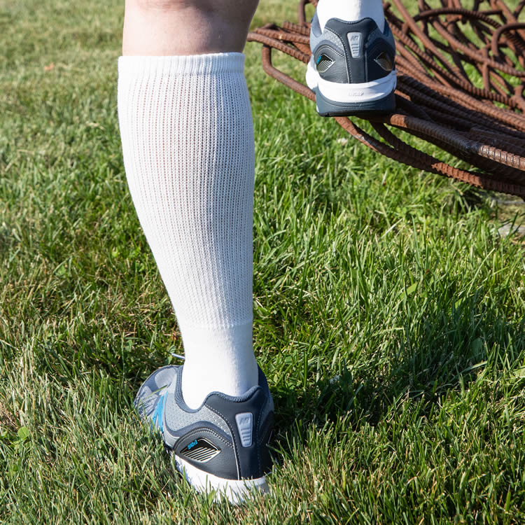 loose fitting (no tight elastic) over the calf sock that will stay up and is suitable for those with regular sized feet, OR for those with wide feet.
