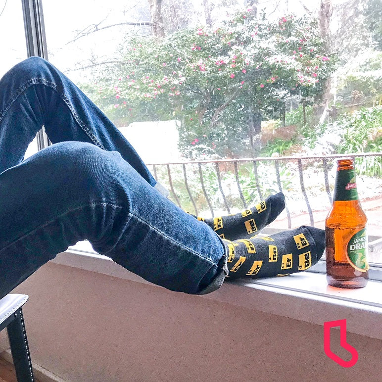 man sitting with beer and beer socks - The Sockery